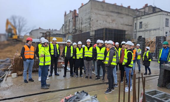 Zdjęcie przedstawia studentów wydziału budownoctwa na placu budowy Osiedla Neonowego w Częstochowie.