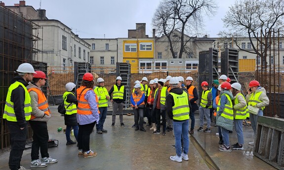 Zdjęcie przedstawia studentów wydziału budownoctwa na placu budowy Osiedla Neonowego w Częstochowie.