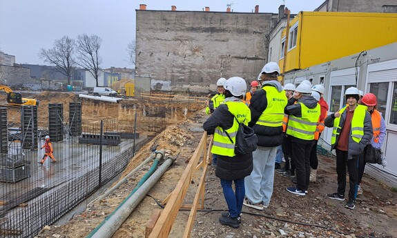 Zdjęcie przedstawia studentów wydziału budownoctwa na placu budowy Osiedla Neonowego w Częstochowie.